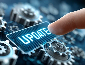 Hand berührt ein blaues Schildchen mit dem Wort UPDATE, umgeben von Zahnrädern.