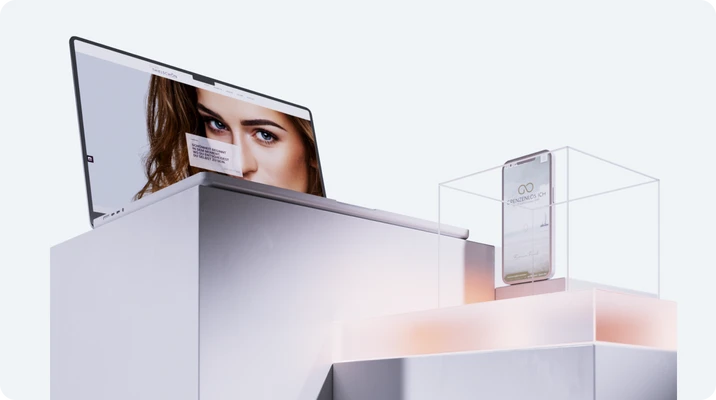 Monitor zeigt das Gesicht einer Frau; daneben ein transparentes Gehäuse mit einem stehenden Gerät auf weißem Podest.