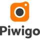 Oranges Kamerasymbol auf dunklem Hintergrund; quadratisches Icon mit dunkler Linse und kleinem weißen Punkt.