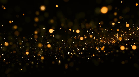 Schwarzer Hintergrund mit vielen goldenen Lichtpunkten unterschiedlicher Größe (Bokeh).