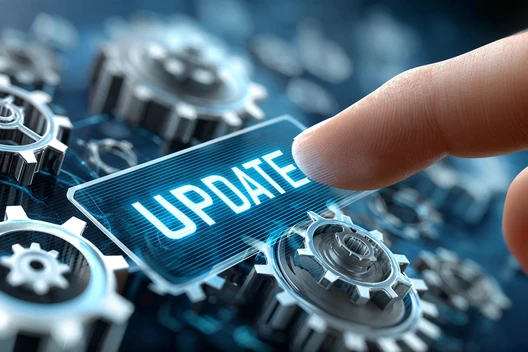 Hand berührt ein blaues Schildchen mit dem Wort UPDATE, umgeben von Zahnrädern.