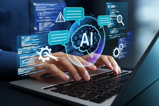 Hände tippen auf Laptop, holografische AI-Grafik mit Chatblasen, Zahnrädern und Codeblöcken über dem Display.