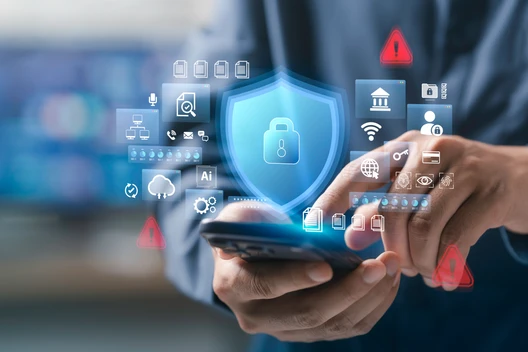 Person hält Smartphone; schwebende Sicherheits-Icons und ein leuchtendes Schild-Symbol um das Gerät.